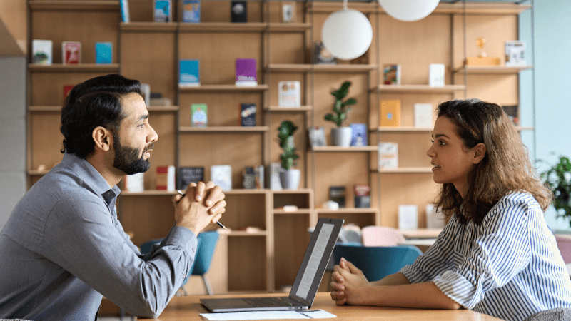 Two people sitting opposite each demonstrating active listening in leadership