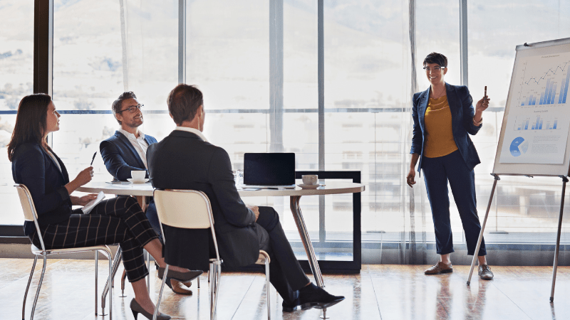 Happy leader presenting to three co-workers