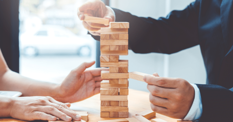Leaders demonstrating business agility to manage challenges through the symbol of Jenga