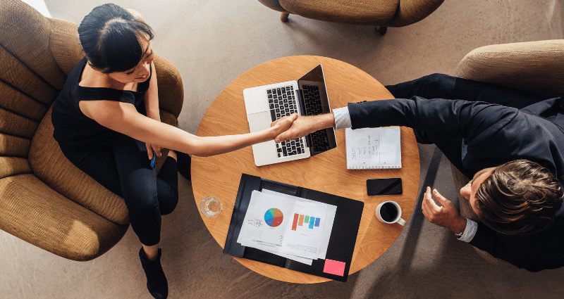 Handshake representing the synergy between management and leadership